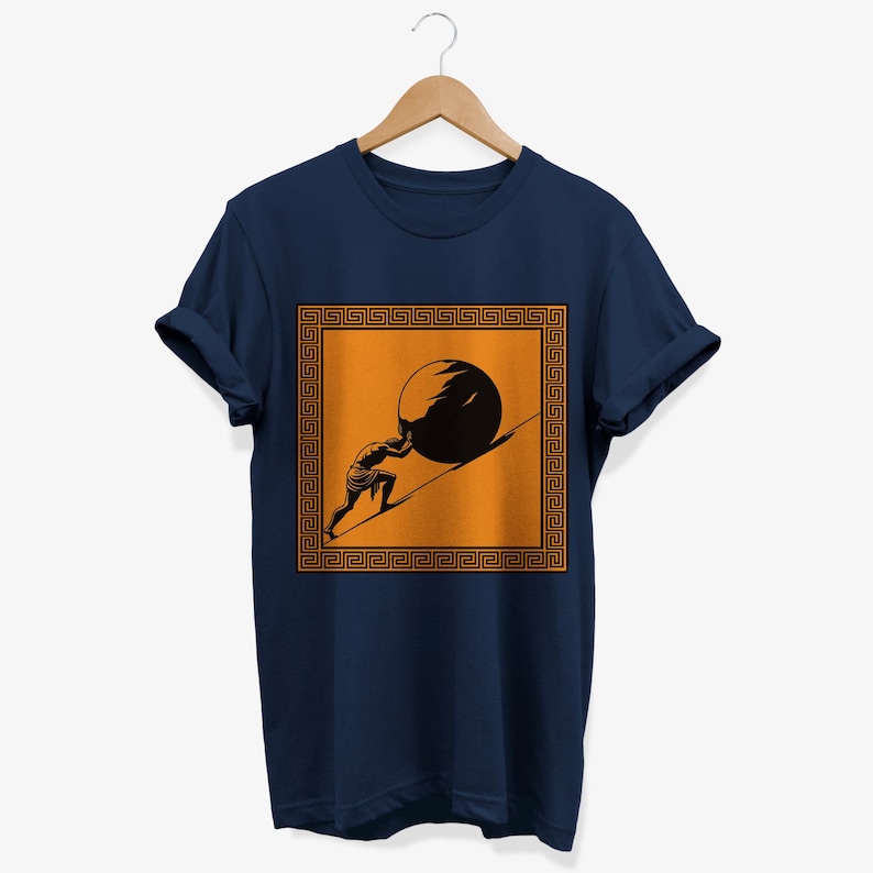 May include: A navy blue t-shirt with a graphic of a person pushing a large stone uphill. The graphic is surrounded by a gold Greek key border.