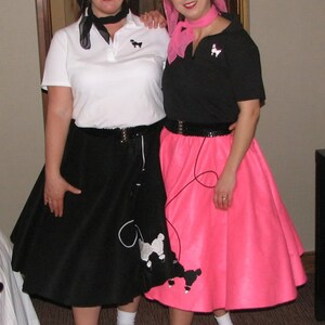 Pu&ograve; includere: Due donne che indossano gonne a ruota e camicie abbinate con disegni di barboncini. Una donna indossa una gonna nera e una camicia bianca con un papillon nero. L'altra donna indossa una gonna rosa e una camicia nera con un papillon rosa.