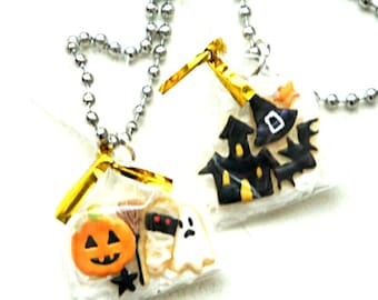 May include: Two silver chain necklaces with Halloween-themed charms. One charm features a ghost, pumpkin, and broom, while the other charm features a black witch's hat and a haunted house.