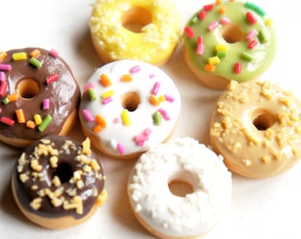 Könnte beinhalten: Eine Sammlung von sechs Mini-Donuts mit verschiedenen Toppings, darunter Schokolade, weißer Zuckerguss mit Streuseln, gelber Zuckerguss, grüner Zuckerguss mit Streuseln und brauner Zuckerguss mit Streuseln.