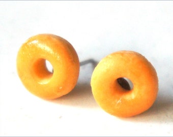 May include: A pair of donut-shaped earrings made of yellow polymer clay.