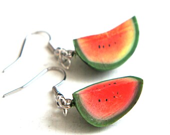 May include: A pair of watermelon slice earrings with silver hooks. The watermelon slices are made of polymer clay and have a realistic appearance.