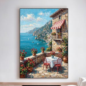 Könnte beinhalten: Ölgemälde einer italienischen Küstenlandschaft. Ein Steingebäude mit einer rot-weiß gestreiften Markise und einem Balkon blickt auf das türkisfarbene Meer. Ein Tisch und Stühle stehen auf einer Steinterrasse, umgeben von roten Topfblumen. Das Kunstwerk ist gerahmt.
