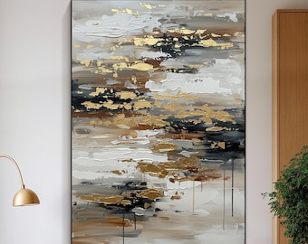 May include: Abstract art painting with a black frame. The artwork features textured brushstrokes in white, gold, brown, and black. The painting is displayed in a modern living room setting, above a white cabinet.