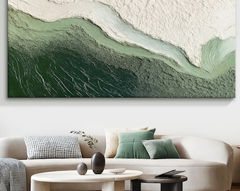 May include: Abstract textured wall art in shades of green and white. The artwork features a layered design with a textured, three-dimensional effect, resembling a landscape or aerial view of a natural environment. The piece is rectangular and mounted on a white wall.