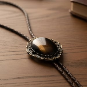Tiger’s eye bolo tie on a desk for a groomsman in a wedding.