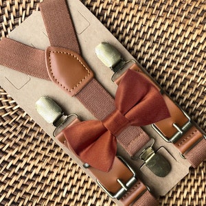 Satin terracotta bow tie with brown cognac suspenders for a fall wedding, groomsmen, or ring bearer outfit.