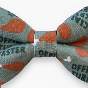 A cat bow tie for Thanksgiving with a pattern of turkeys on it.