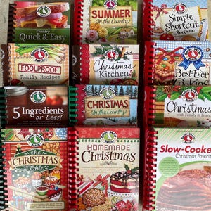 May include: A collection of twelve spiral-bound Gooseberry Patch cookbooks featuring various titles including Country Quick & Easy, Summer in the Country, Simple Shortcut Recipes, Foolproof Family Recipes, Christmas Kitchen, Best-Ever Cookies, 5 Ingredients or Less, Christmas in the Country, Christmas with Family & Friends, The Christmas Table, Homemade Christmas, and Slow-Cooker Christmas Favorites.