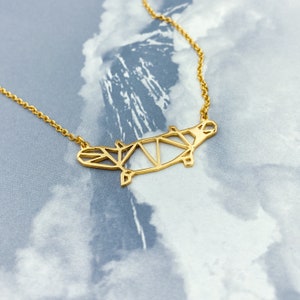 Peut inclure: Un collier en or avec un pendentif en forme d'hippopotame g&eacute;om&eacute;trique. Le pendentif est fait de m&eacute;tal fin et pr&eacute;sente un design d&eacute;licat et complexe.