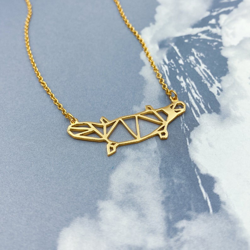 Peut inclure: Un collier en or avec un pendentif en forme de ornithorynque g&eacute;om&eacute;trique. Le pendentif est fait de m&eacute;tal fin et pr&eacute;sente un design d&eacute;taill&eacute;.