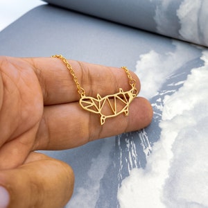 Peut inclure: Un collier dor&eacute; avec un pendentif platypus g&eacute;om&eacute;trique. Le pendentif est en m&eacute;tal fin et pr&eacute;sente un design d&eacute;taill&eacute;.