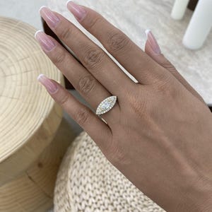 Anello di fidanzamento con diamante sintetico taglio marquise da 1 carato, colore E/VVS2, montatura in oro giallo 14 carati e 2 pietre laterali rotonde a taglio brillante.