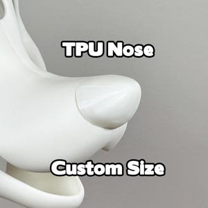 May include: Close-up of a white, cartoon-style dog head with a TPU nose. The text "TPU Nose" and "Custom Size" are displayed in bold, black letters.
