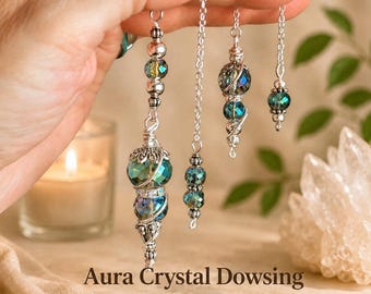 May include: A set of four dowsing pendulums featuring iridescent teal and blue crystal beads accented with silver-toned metal wire wrapping and chain links. The beads exhibit a reflective aura finish, suspended from delicate silver-colored metal chains.
