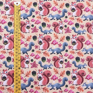 May include: A beige fabric with a repeating pattern of red squirrels holding acorns, blue squirrels, red and white mushrooms, and brown leaves.