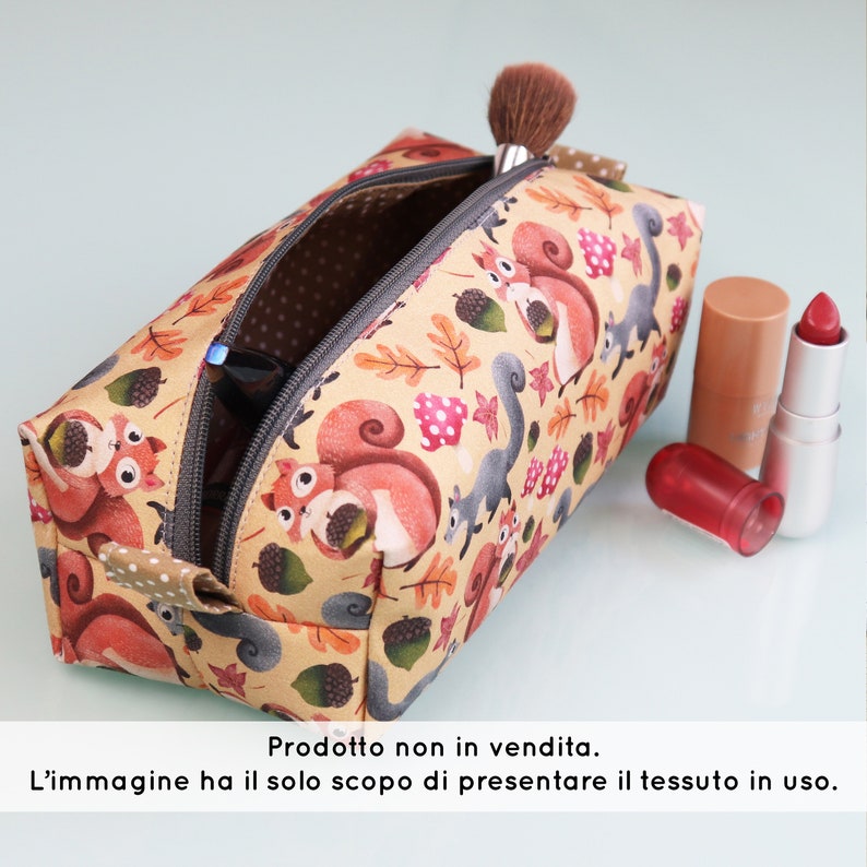 May include: A beige zippered pouch with a squirrel and acorn print. The pouch is open and has a pair of sunglasses inside.