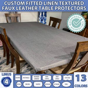 May include: A grey linen textured faux leather table protector with a waterproof and disinfectable label. The table protector is fitted and comes in 13 colours. The image shows the table protector on a table with chairs.