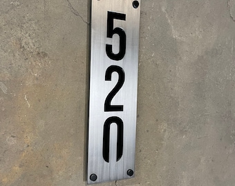 May include: A brushed silver metal house number sign with black numbers. The number is 520.