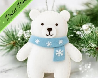 May include: A white felt polar bear ornament featuring a light blue scarf with white embroidered snowflake details. The bear has black eyes and a black nose, with a silver hanging loop at the top. A green diagonal banner displays the text Digital Pattern.