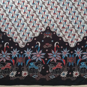 May include: A patterned textile with a repeating design of stylized flowers and diamond shapes in red, blue, and white on a cream background. The bottom border has elephants and floral motifs on a black background.