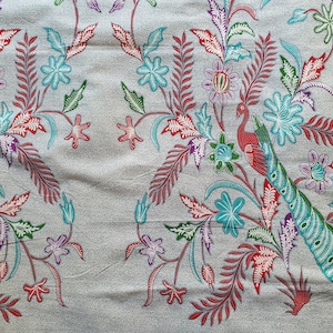 Könnte beinhalten: Ein grauer Stoff mit einem sich wiederholenden Muster aus Pfauen, Blumen und Blättern. Das Design weist rote, türkisfarbene, violette und grüne Elemente auf. Der Stoff hat ein strukturiertes Aussehen.