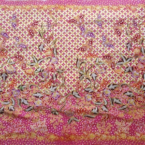 Könnte beinhalten: Ein lebendiger Stoff mit einem sich wiederholenden Muster aus weißen und gelben Rauten, mit einem rosa Rand. Das Design umfasst Blumen- und Schmetterlingsmotive in Rot-, Lila- und Brauntönen.