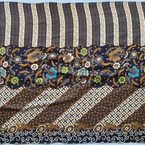 May include: A patterned fabric with a dark blue background. The design includes stripes, floral motifs, and geometric patterns in shades of brown, white, and blue. The fabric has a wavy border and a repeating pattern.