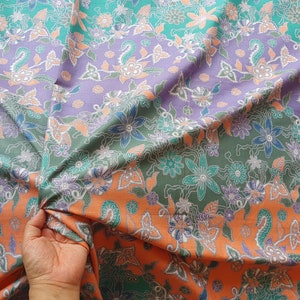 Indonesian batik fabric floral design in soft green, orange and purple pastel colours