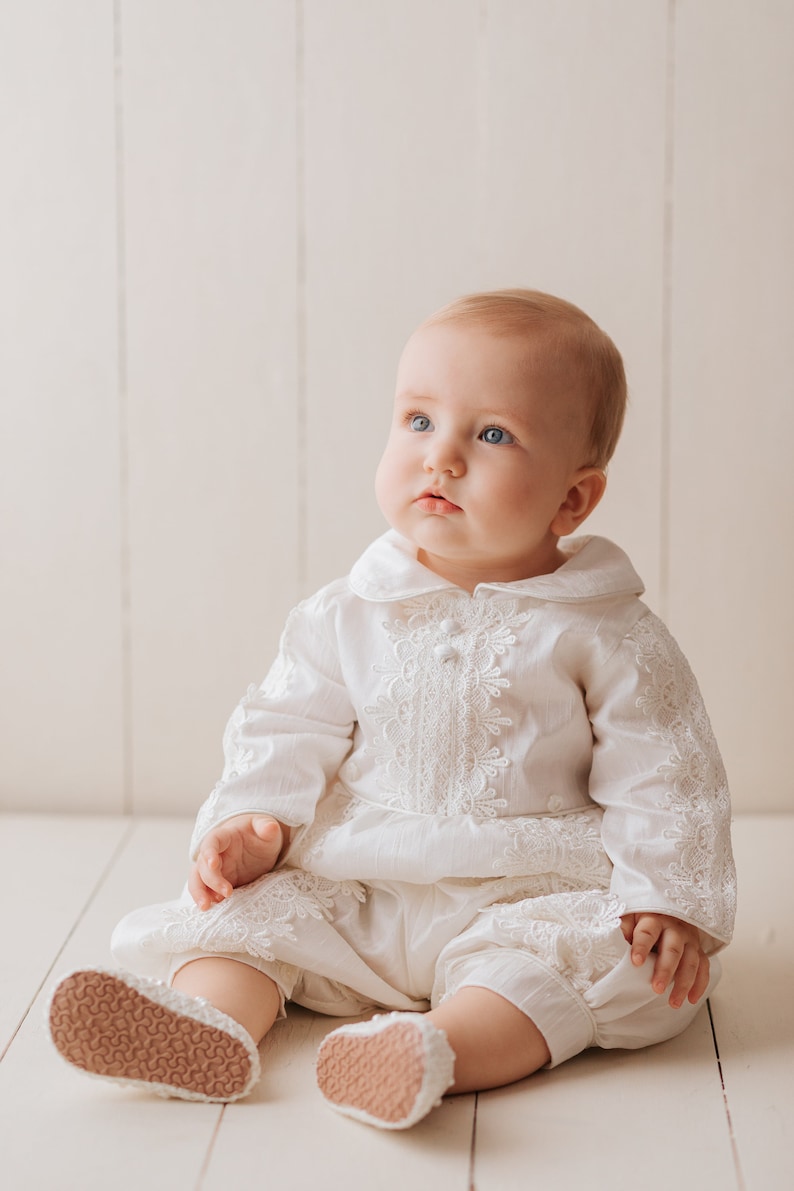 Detachable christening gown for a child with long ivory sleeves, with fine embroidered details, with high quality fabric to provide comfort to the baby