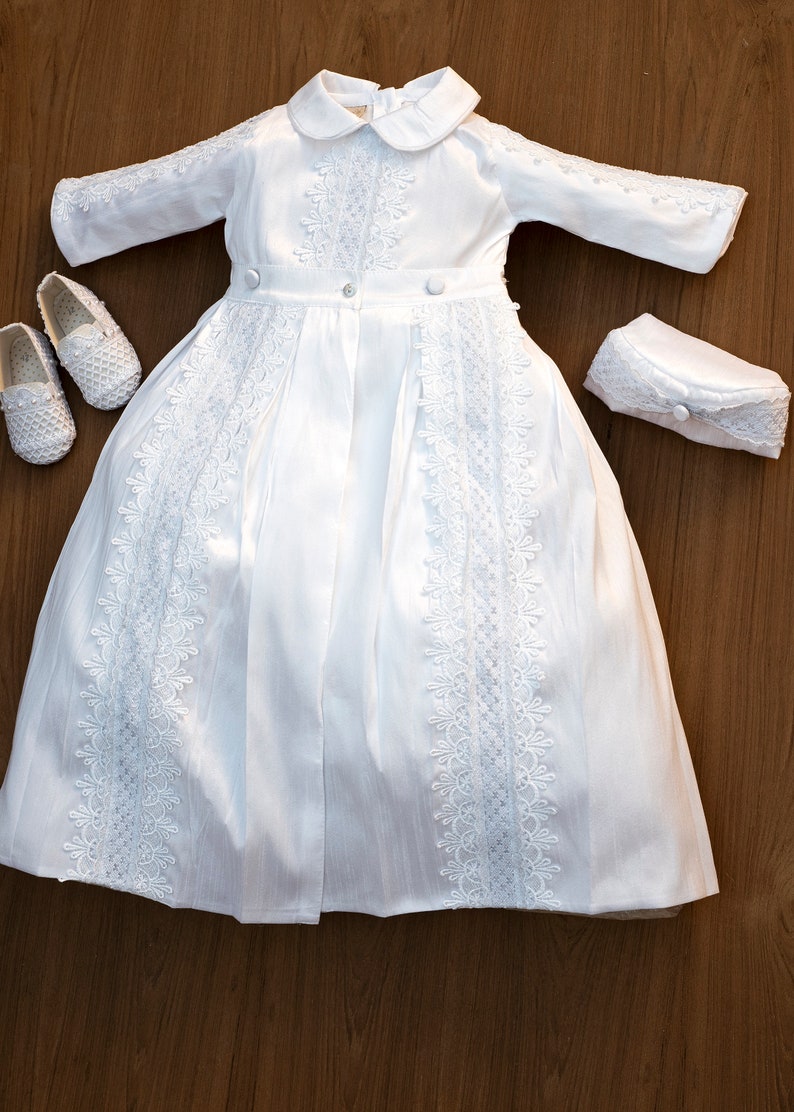 Detachable baptism robe for a boy with white long sleeves, with fine embroidered details, with high quality fabric to provide comfort to the baby. He has a hat that matches the baptismal robe.