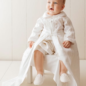 Detachable christening gown for a child with long ivory sleeves, with fine embroidered details, with high quality fabric to provide comfort to the baby