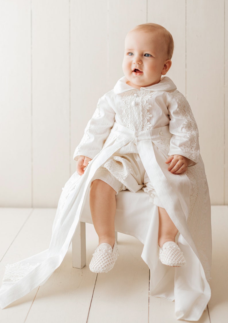 Detachable christening gown for a child with long ivory sleeves, with fine embroidered details, with high quality fabric to provide comfort to the baby