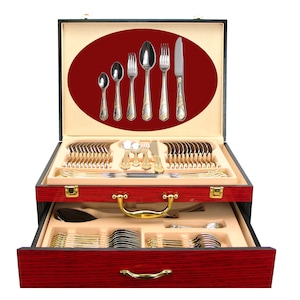 May include: A red wooden case with a gold handle and a drawer, containing a set of gold-trimmed silverware. The case is open, revealing the silverware inside.