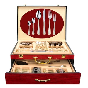 May include: A red wooden case with a gold handle and gold accents. The case is open, revealing a set of gold-plated silverware. The silverware is arranged in a neat and organized fashion. The case is a beautiful and elegant way to store and display a set of silverware.