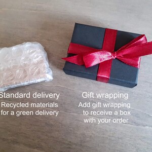 Default packaging (cardboard and bubble-wrap) next to the shipping upgrade (black box with red ribbon for gift giving).