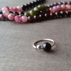 Tourmaline hoop against a wooden background.
