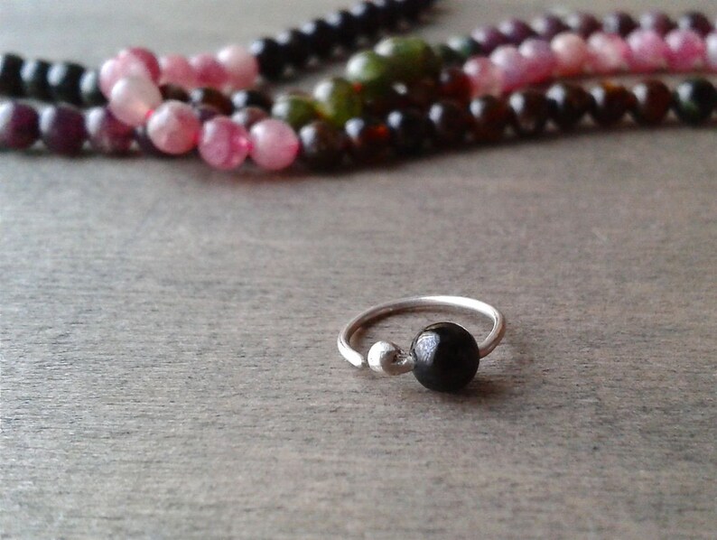 Tourmaline hoop against a wooden background.