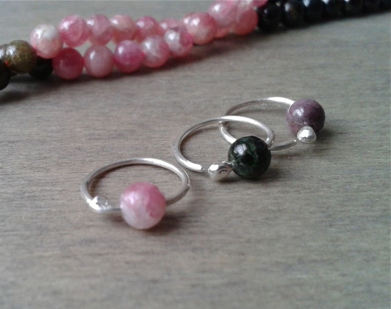 Tourmaline hoops against a wooden background.