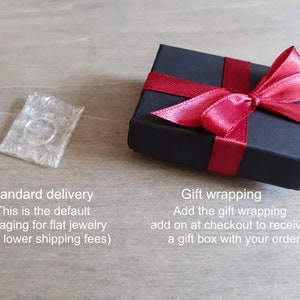 Default packaging (bubble-wrap) next to the shipping upgrade (black box with red ribbon for gift giving).