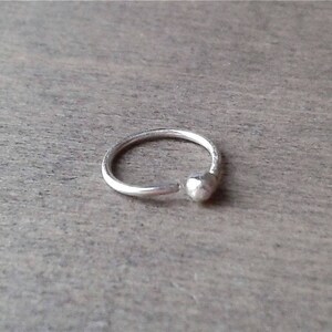 Sterling silver hoop against a wooden background.