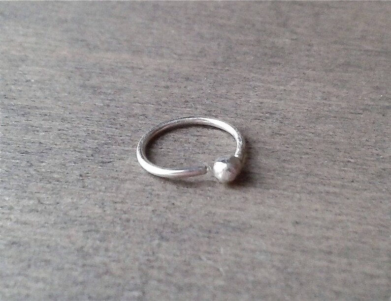 Sterling silver hoop against a wooden background.