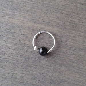 Tourmaline hoop against a wooden background.