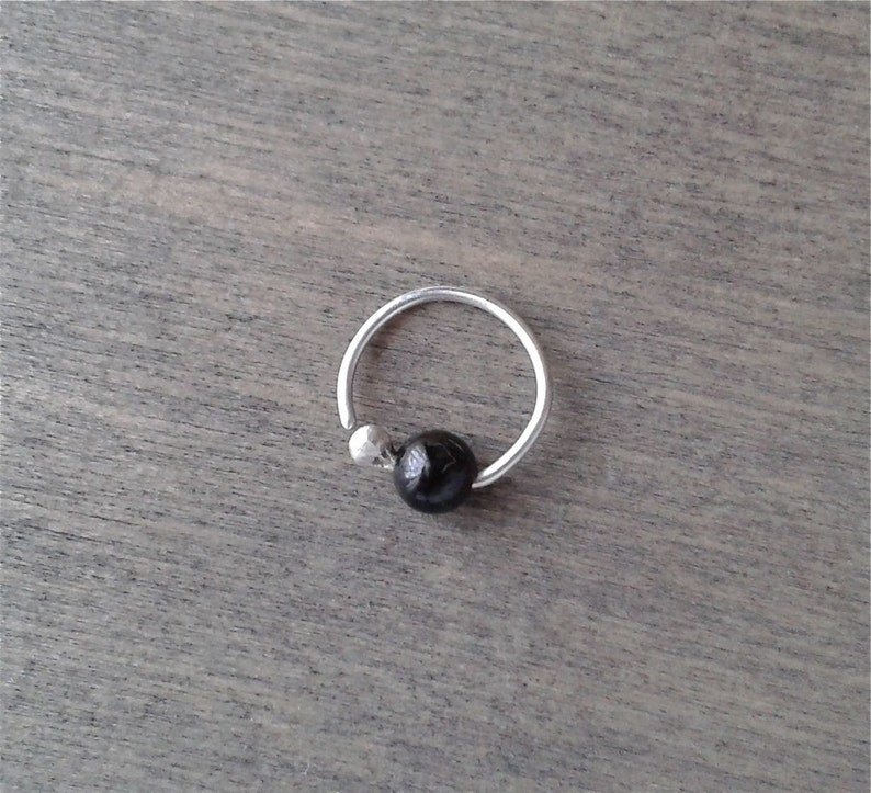 Tourmaline hoop against a wooden background.