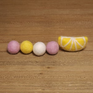 May include: A garland of felt balls in pink, yellow, and white with a felt lemon slice.