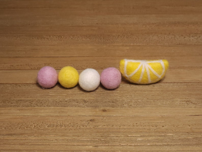 May include: A garland of felt balls in pink, yellow, and white with a felt lemon slice.