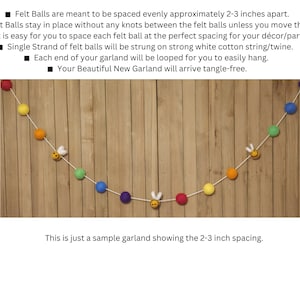 May include: A colorful felt ball garland with a white string and bee charms. The garland is hanging on a wooden wall. The felt balls are spaced approximately 2-3 inches apart. "This is just a sample garland showing the 2-3 inch spacing."