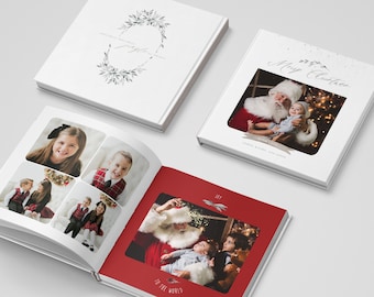 May include: White hardcover photo books with Christmas-themed images. One book features a wreath design and the words "Jingle all the way." Another displays Santa Claus with a baby and the words "Merry Christmas." The open book shows family photos.