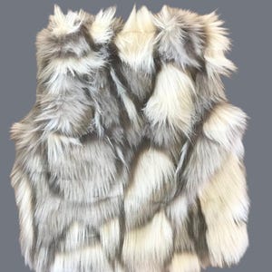Cozy and stylish Kids' Fur Vest in a blend of grey, black, brown, and cream. Perfect for layering over any outfit, this well-made vest keeps your child warm and photo-ready. The versatile colors make it easy to mix and match with her wardrobe.