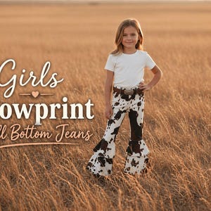 Puede incluir: Una niña en un campo lleva una camiseta blanca y unos vaqueros de campana con estampado de vaca. Los vaqueros tienen un patrón en blanco y negro con la parte inferior acampanada. El texto "Girls Cowprint Bell Bottom Jeans" se muestra en la imagen.